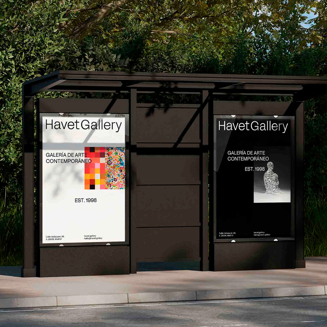 Havet_Gallery_WSC_Branding • WSC® Two HavetGallery posters displayed at an outdoor shelter: a white poster with a colorful mosaic and 'EST. 1998,' and a black poster with a small sculpture image and gallery text.